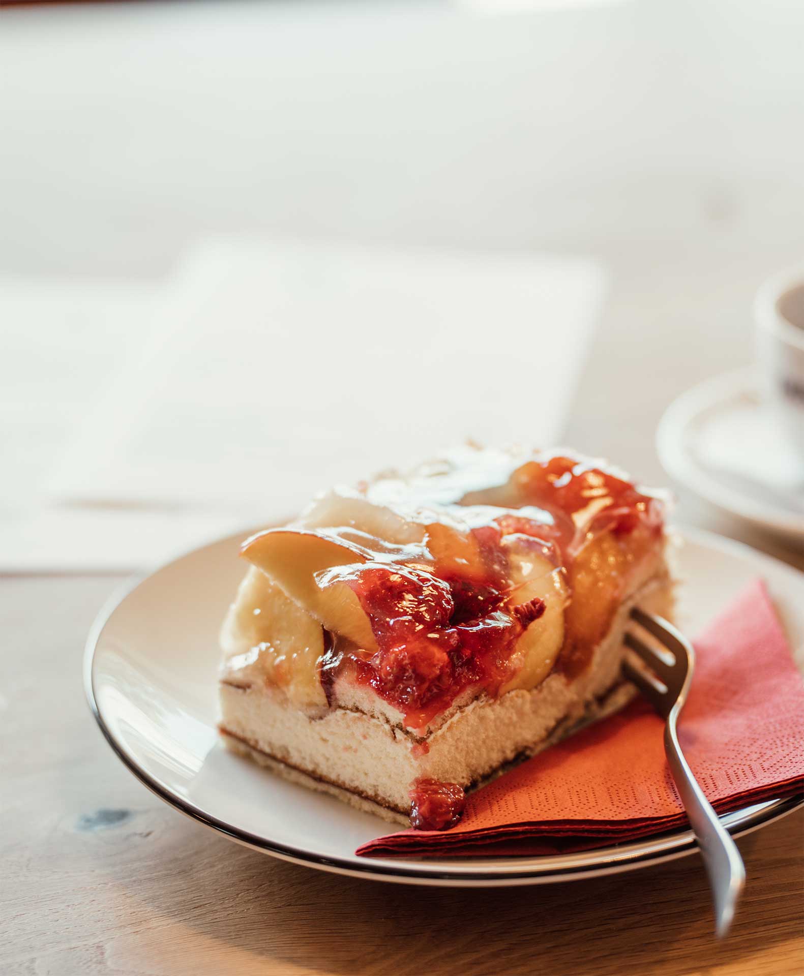 Stück Obstkuchen auf einem Teller mit Gabel.